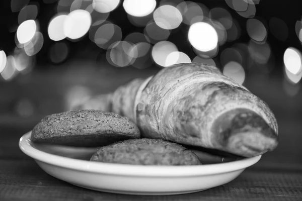 Croissant and oat cookies on white plate. Winter holiday tradition. Sweets for Santa Claus and his helpers. Santa treats recipe. Treats for Santa concept. What do kids around world leave for Santa — Stock Photo, Image