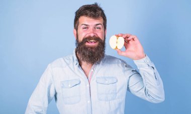 Adam gülümseyen tutan apple mavi arka plan sakallı. Vitamini beslenme diyet sağlık. Yarım elma sağlıklı yaşam tarzı. Hipster doğal ekolojik elma gösterir. Besin değeri kavramı
