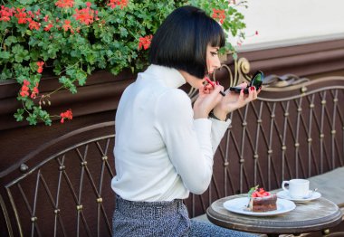 Makyaj kavramı. Kız esmer aynaya bakmak ruj makyaj görünüşünü kontrol edin. Kız gibi sırları kavramı. Kadın cep aynası ile makyaj yapma. Tarihinden önce her şeyin doğru olup olmadığını kontrol edin
