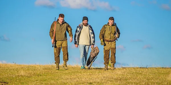 Jägare med vapen gå soliga höst dag. Brutala hobby. Gruppen män jägare eller skogvaktare natur bakgrunden blå himmel. Killar samlades för jakt. Män bär jaktvapen. Jakt som hobby och fritid — Stockfoto