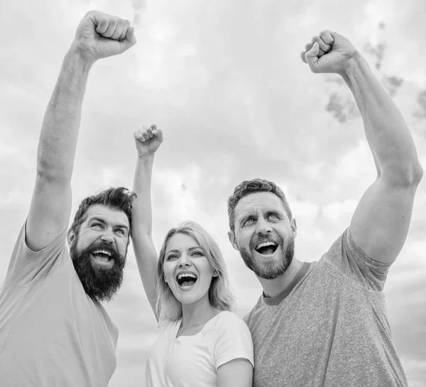 La mujer y los hombres se ven seguros de éxito fondo del cielo. Comportamientos del equipo cohesivo. Celebra el éxito. Sí que podemos. Formas de construir un equipo cohesivo. Trío de pie feliz con confianza con los puños levantados — Foto de Stock