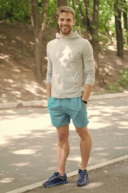 Sporcu pedometre gadget ile eğitim. Spor araç konsepti. Adam atlet Spor donatımı, Doğa arka plan ile poz mutlu yüzünde. Kıl fitness izci veya pedometer ile sporcu