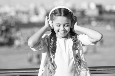 Küçük kız müzik dinleme keyfini en sevdiğim şarkı. Kız kulaklık kentsel arka plan ile. Müzik olumlu etkisi. Müzik modern kulaklık zevk kız çocuk. Çocukluk ve gençlik müzik tadı