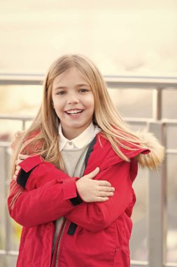 Bulanık çevre üzerindeki çarpı işareti silah gülümsemeyle evlat. Sonbahar gün açık sarı uzun saçlı kız. Macera, keşif, yolculuk. Tatil, kavram seyahat. Kırmızı montlu çocuk ayağa köprüde.