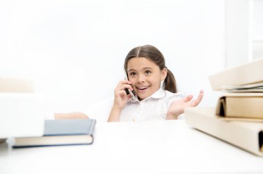 Yeni iletişim teknolojileri okul eğitiminde kullanarak. Küçük kız cep telefonu üzerinde ders üzerinde konuşurken. Telefon görüşmesi olan küçük okul çocuğun. Kız öğrenci gelişmekte olan iletişim becerileri. Bir arama varlık