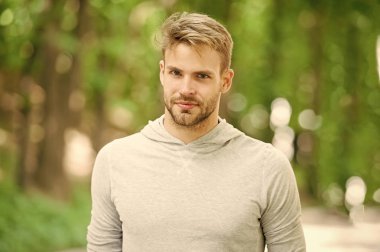 Kıl üstünde sakin yüz, Doğa arka plan, defocused olan adam. Cilt bakım kavramı. Adam sakal veya tıraşsız adam görünüyor yakışıklı açık. Adam sakallı ve çekici görünüşü hakkında umurunda değil.