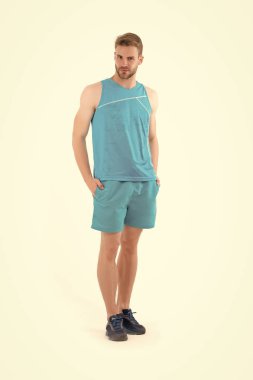 Sporcu aktif giyim ve ayakkabı beyaz arka plan üzerinde izole çalıştırmak için. Mavi spor giyim ve spor ayakkabı sakallı adam. Spor moda stil ve eğilim. Eğitim ve egzersiz etkinlik