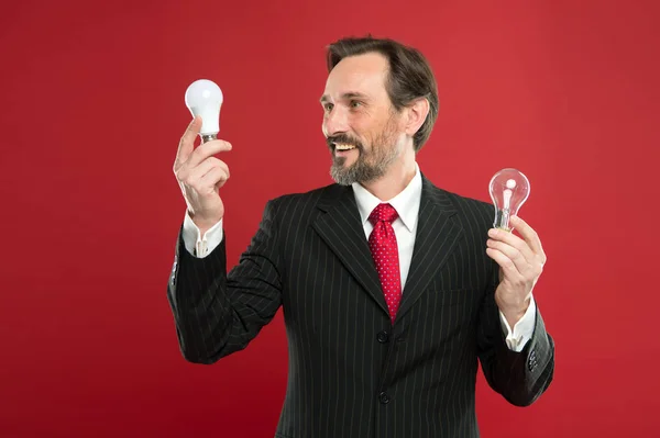 Need fresh ideas. Electricity and energy. Businessman in suit hold light bulb. Man with beard search for inspiration. Lamp. Mature bearded man with lamp. Power saving. Male in business outfit