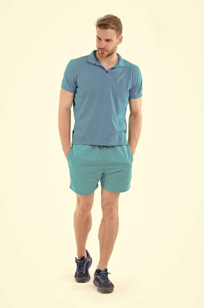 Un sportif confiant. Pleine longueur bel homme en bleu vêtements de sport et baskets isolé fond blanc. Athlète confiant met les mains dans les poches. Concept de masculinité et de confiance — Photo