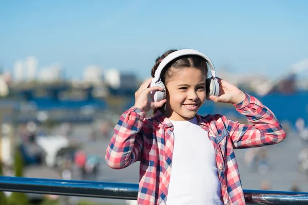Girl child listen music outdoors with modern headphones. Kid little girl listen song headphones. Music account playlist. Customize your music. Discovering new music styles is great way into culture