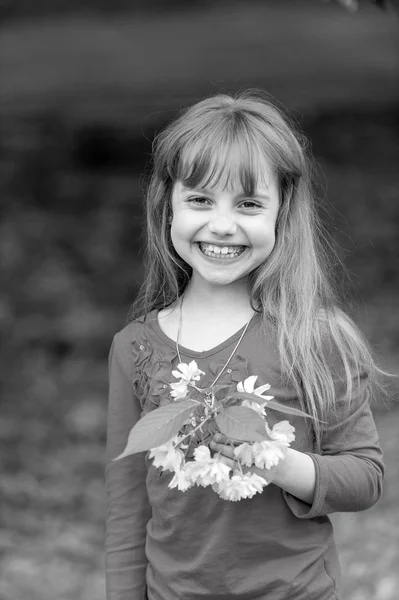 Kleine babymeisje houdt voorjaar sakura bloem — Stockfoto