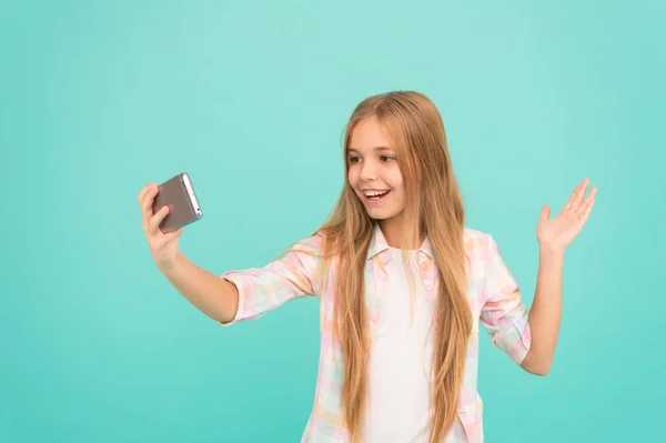 Hej världen detta är min kanal. Låt mig ta selfie. Barn tjej håll smartphone. Videosamtal-konceptet. Flickan håller smartphone tar selfie. Selfie för sociala nätverk. Streaming online eller skytte vlog — Stockfoto