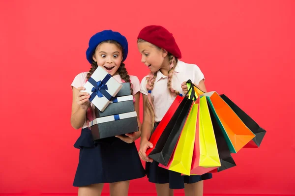 ¿Qué hay ahí? Niños pequeños con bolsas de papel y envolturas después de comprar. Niños pequeños con bolsas de papel y paquetes. Pequeños compradores. Chicas pequeñas con bolsas de compras y cajas. Compras es una adicción —  Fotos de Stock