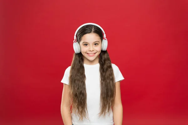 Ela adora o som incrível dos auscultadores. Uma menina a ouvir música. Menina bonito usando fones de ouvido estéreo. Adorável fã de música. Criança gosta de música tocando em fones de ouvido — Fotografia de Stock