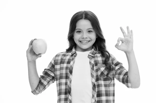 School snack concept. Healthy nutrition diet. Apple vitamin snack. Girl cute long curly hair holds apple fruit white background. Child girl casual clothes holds apple. Child kid happy face like apple Stock Photo