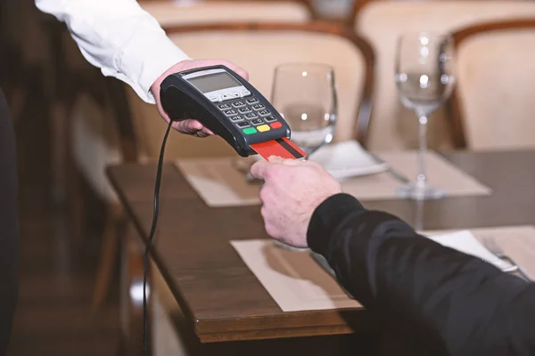 Man hand with credit card swipe through terminal for sale