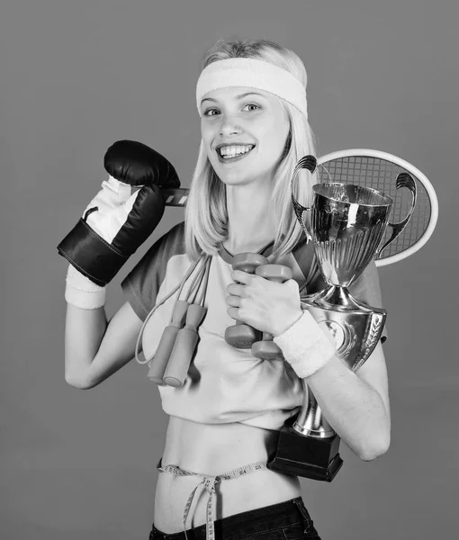 Girl successful modern woman hold golden goblet of champion. Woman good in tennis jumping boxing fitness sport. How to find time for everything. Sport champion. Fitness champion. Champion concept