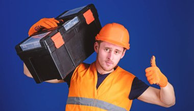 Onarım istişare kavramı. Kask, kask içinde adam araç kutusu tutar ve yukarı hareketi, mavi arka plan gösterir. İşçi, repairer, tamirci, emin yüz taşıyan araç omuz üzerinde Oluşturucu