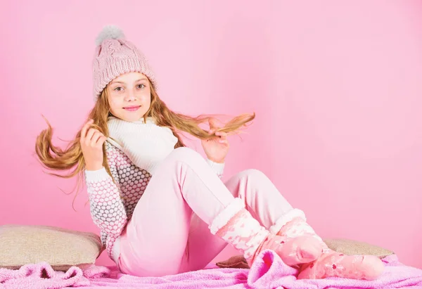 Kid lachende fotomodel. Jongen meisje draag leuke gebreide muts van modieuze en comfortabele gezellige kleding. Winter mode concept. Meisje lang haar ontspannen roze achtergrond. Winter mode voor kinderen — Stockfoto