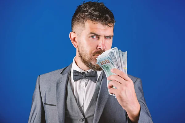 Businessman got cash money. Richness and wellbeing concept. Get cash money easy and quickly. Smell of money. Easy cash loans. Man formal suit hold pile of dollar banknotes blue background