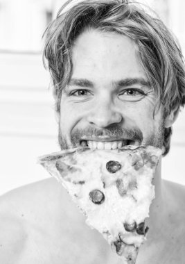Gıda teslim Servisi. Yakışıklı adam bir parça pizza elinde tutar ve bu yemek. Adam pizza kutusu sit yatak yatak odası ya da otel odasında tutar. Yemeği paylaşmak.