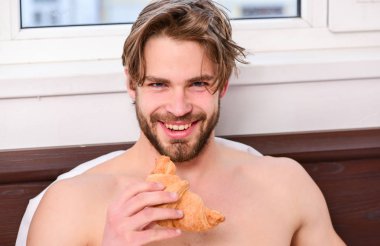 Adam yakışıklı adam yatakta kahvaltı sakallı. Yakışıklı adam sabah yatakta kahve içme. Onun sabah fincan kahve yatak otel Oda mutlu gülümseyen içinde döşeme zevk yakışıklı genç.