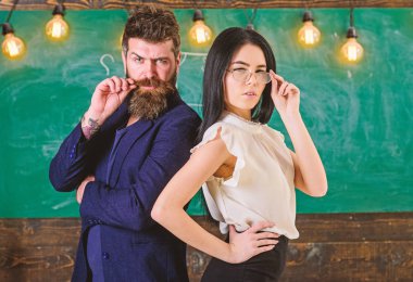 Sakal ve gözlük stand sırt sırta, kara tahta arka plan öğretmen olan adam. Bayan ve birlikte okulda çalışan hippi. Öğretmen ve öğretmen rahat görünüyor. Ekip çalışması kavramı