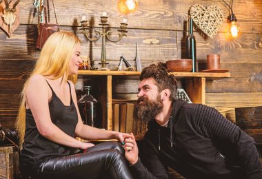 Çift gamekeepers evde, ahşap iç arka plan romantik akşamın. Aşık çift birlikte ellerini tutar. Kız ve erkek gülümseyen yüzler üzerinde sıcak atmosferinin keyfini çıkarın. Teklif kavramı