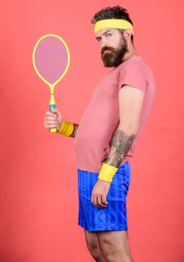 Adam hipster giyim eski okul spor kıyafeti bandaj ile sakallı. Tenis kilo vermek için etkili bir yol olabilir. Elinde kırmızı bir arka plan üzerinde atlet tutun tenis raketi. Tenis spor. Tenis Kulübü kavramı