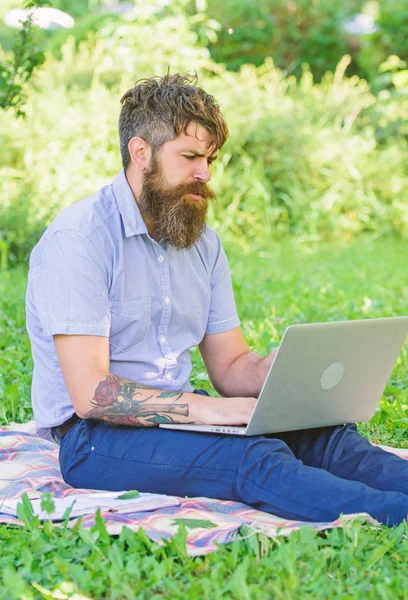 Man bearded with laptop nature background. Blogger create content for social network. Writer or blogger write post for social network. Inspiration for blogging. Blogger becoming inspired by nature
