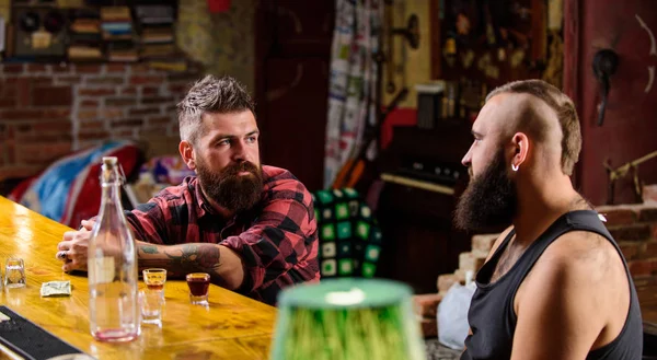 Hipster hombre barbudo pasar el ocio con un amigo en el mostrador del bar. Hombres relajándose en el bar. Bebidas alcohólicas fuertes. Viernes de relajación en el bar. Horario de apertura hasta los últimos visitantes. Amigos relajándose en el bar o pub — Foto de Stock