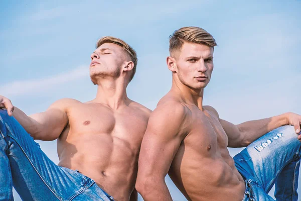 Attractive twins relaxing. Men muscular chest naked torso sky background. Masculinity and sexuality. Men muscular athlete bodybuilder relaxing lean each other. Sexy torso attractive body strong macho.