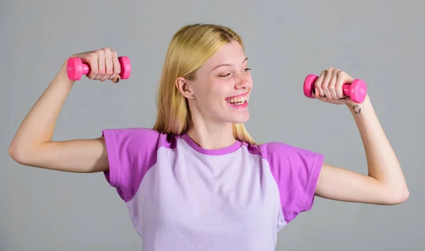 Woman fitness coach exercising with dumbbells. Easy exercises with dumbbells. Workout with dumbbells. Biceps exercises for female. Girl hold dumbbells. Fitness instructor. Healthy lifestyle concept