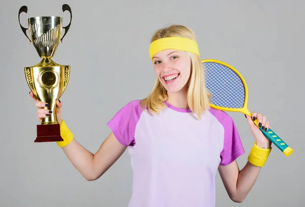 Vincere una partita di tennis. Le donne indossano abiti sportivi. Il tennista vince il campionato. Primo posto. Risultati sportivi. Festeggia la vittoria. Campione di tennis. Ragazza atletica tenere racchetta da tennis e calice d'oro — Foto Stock