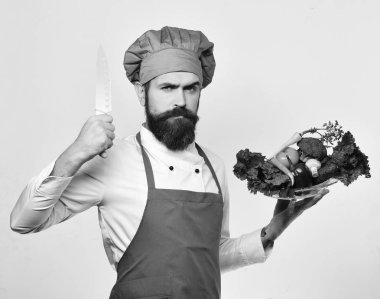 Burgonya üniformalı aşçı salata malzemesi taşıyor.