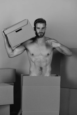 Sakallı, baştan çıkarıcı yüzlü, omuzlarında karton taşıyan maço.