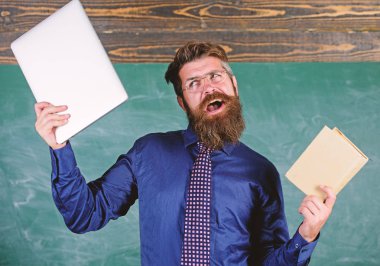 Ne tercih ederim. Öğretmen sakallı hippi kitap ve laptop tutar. Öğretmen modern öğretim yaklaşımı seçme. Dijital kağıt karşı. Şu öğretim yöntemi seçin. Kağıt kitap dizüstü karşı