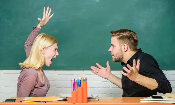 Conflito escolar. Mulher zangada vai ao homem com os punhos. Professora e professora estão em discussão. Um casal a discutir na sala de aula. Estudantes universitários ou universitários de volta à escola. Ensino médio — Fotografia de Stock