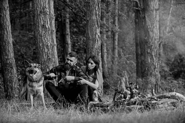 Coppia con cane pastore tedesco vicino al falò, — Foto Stock