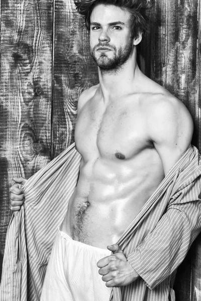 Bachelor sexy body chest and belly. Guy shimmering skin undressing bathrobe. Man athlete with fit torso. Sexy attractive macho tousled hair on wooden background. Sportsman show six pack sexy torso — Stock Photo, Image