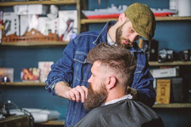 Sakal hipster istemcisinin damat ile meşgul berber, güzellik arka plan sağlar. Sakallı hippi şık berber dükkanı olarak profesyonel kuaför tarafından hizmet veren cape kaplı. Damat kavramı