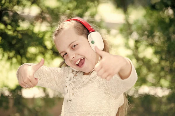 Nettes kleines Mädchen genießt Musik mit Kopfhörern — Stockfoto