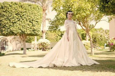 Tavsiye ve ipuçları düğün yurtdışında uzmanlar. Peri masalı giysi. Şeyler yurtdışında düğün için göz önünde bulundurun. Gelin çok güzel beyaz gelinlik güneşli gün palmiye ağaç arka plan. Düğün töreni tropik ada