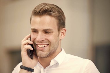 Her zaman kullanılabilir. Bakımlı beyaz gömlek uzun kol telefonu kentsel arka plan konuş. Adam yakışıklı çekici ofis çalışanı biliyor cep telefonu. İşadamı ciddi mutlu çağrı sırasında öğle yemeği zaman mobil