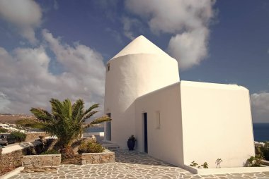 Badanalı bina ve palmiye Mykonos, Yunanistan. Deniz güneşli mavi gökyüzü üzerinde eve. Tipik ev mimarisi ve tasarım. Bir Akdeniz Adası yaz tatili. Yolculuk tutkusu ve seyahat kavramı