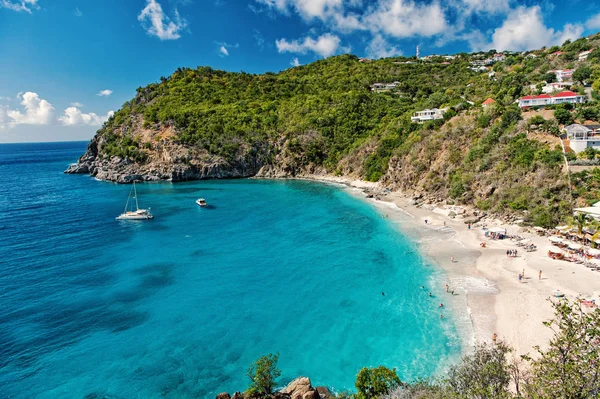 Harbor with sand beach, blue sea and mountain landscape in gustavia, st.barts. Summer vacation on tropical beach. Recreation, leisure and relax concept. Wanderlust and travel with adventure