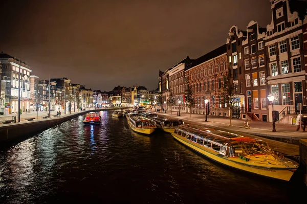 Water street with boats and buildings by night in Amsterdam — Stock Photo, Image