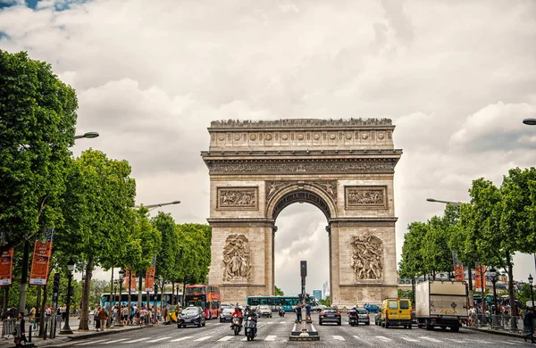 París, Francia - 02 de junio de 2017: Monumento al arco en el centro de la concurrida avenida. Arco del Triunfo en el cielo nublado. Vacaciones y turismo en la capital francesa. Concepto de liberación y honor de la victoria — Foto de Stock