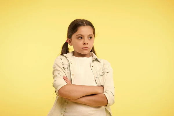 I do not want to see you. After dispute. Girl serious face offended yellow background. Kid unhappy looks strictly. Girl folded arms on chest looks serious. Sensitive girl not want to talk — Stock Photo, Image