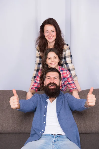 Feliz paternidad. Relaciones estrechas y confiables. Concepto de valores familiares. Bonos familiares. La familia pasa el fin de semana juntos. Familia amigable divirtiéndose juntos. Mamá papá y su hija relajarse en el sofá — Foto de Stock